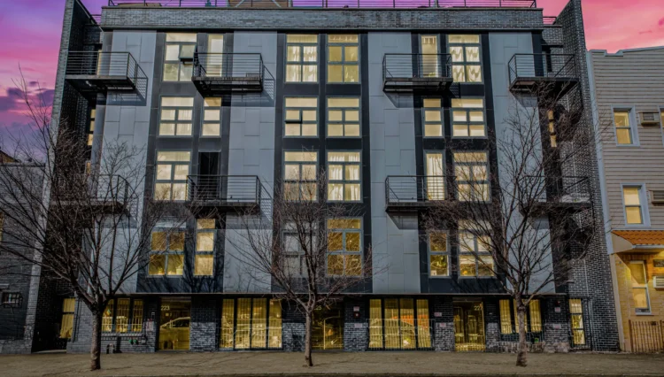 Modern apartment building with trees in front.