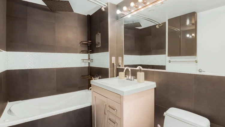 Modern bathroom with tub, vanity, and toilet.