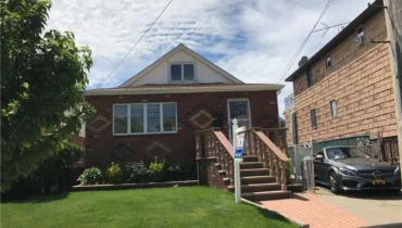 Brick house with a front yard and steps.