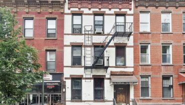 Three brick row houses with fire escape.