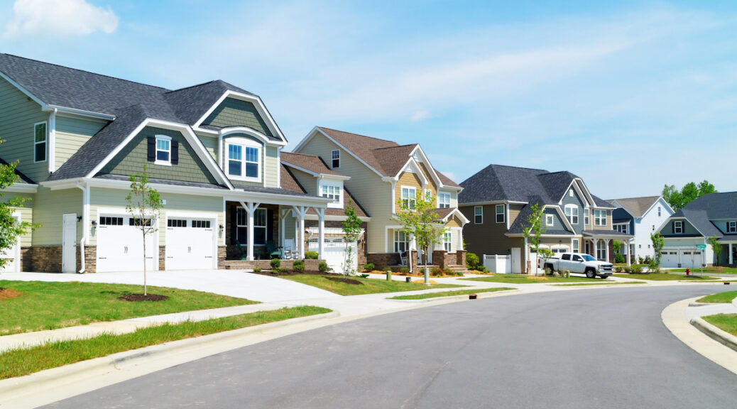 Suburban street with houses and a truck.