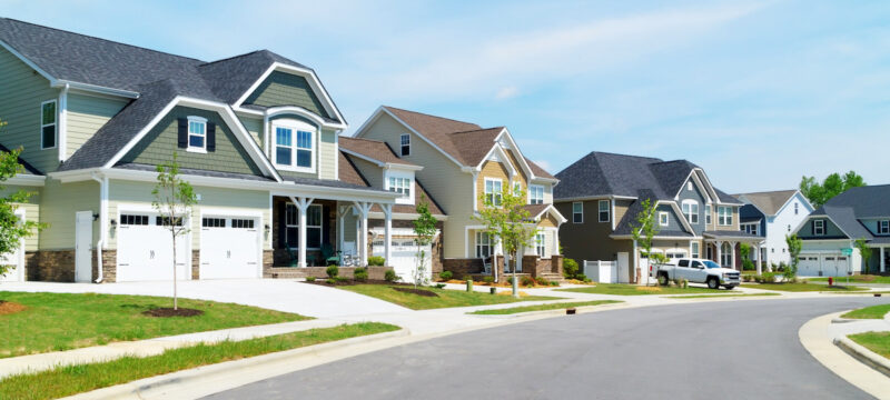 Suburban street with houses and a truck.