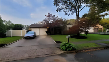 A car parked in the driveway of a home.