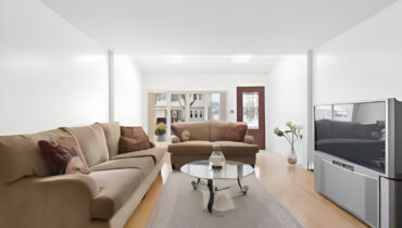 Beige couch, coffee table, and large TV.