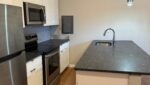 Modern kitchen with stainless steel appliances.